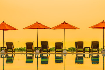 Beautiful sunrise around with umbrella and chair outdoor swimming pool