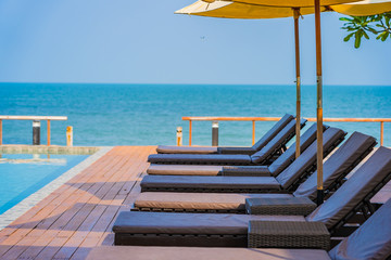 Beautiful empty chair umbrella around outdoor swimming pool in hotel resort for travel