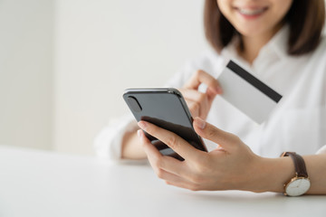 woman holding credit card and payment online on smartphone.