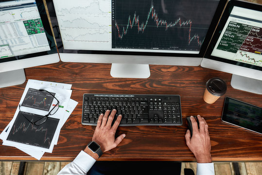 Achieve Best. Top View Of Businessman, Trader Working, Sitting By Desk In Front Of Multiple Computer Monitors. Stock Trading Forex With Technical Indicator Tool. Hands On Keyboard.