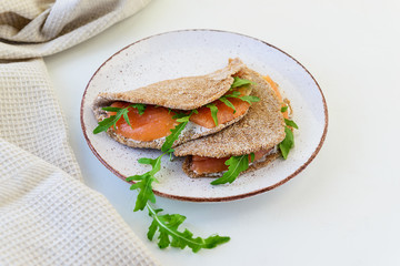 Rye cakes with salmon, arugula and goat cheese on a plate. Healthy food, gluten free.