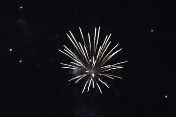 A flash of plain white fireworks. In the night sky