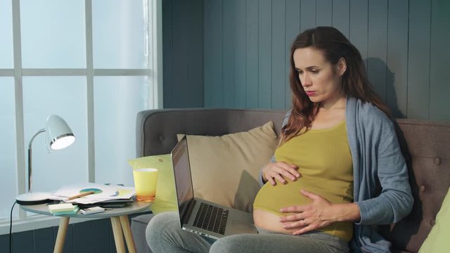 Closeup pregnant businesswoman making breathe exercises on couch at home.