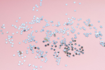 Silver stars shine on a bright pink background. Festive holiday bright background.