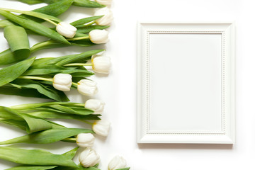 Frame for text and white tulip on white. Top view.