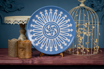 Decorative, painted plate on a gray background.