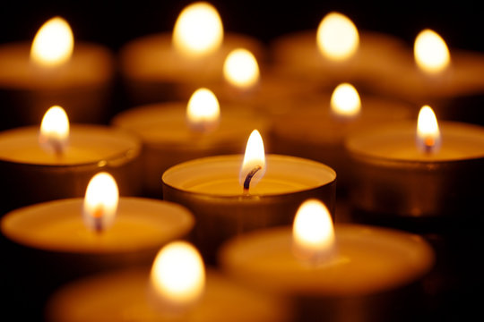 Burning candles on black background, shot with shallow depth of field
