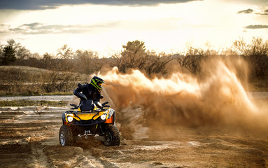 Racing powerful quad bike on the difficult sand in the summer.
