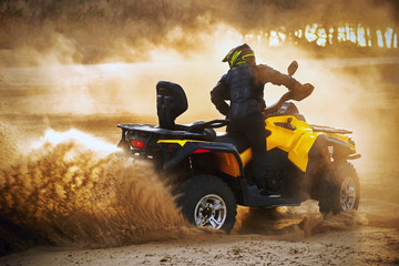 Racing powerful quad bike on the difficult sand in the summer. © Bondariev Volodymyr.