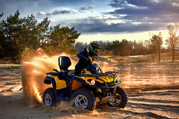 Racing powerful quad bike on the difficult sand in the summer.