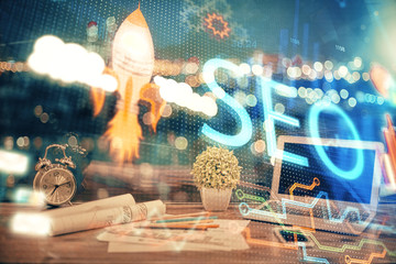 Multi exposure of table with computer and seo drawing hologram. Search optimization concept.