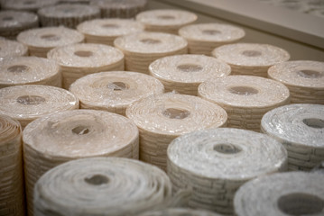 Conveyor of wallpaper rolls in a shop or manufacture