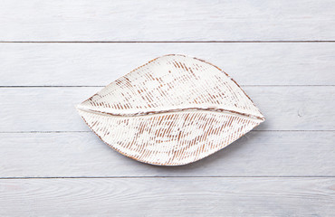 Wooden leaf shaped tray on grey background. Top view. Copy space.