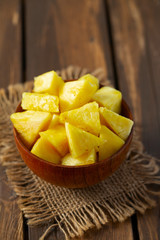 fresh pineapple pieces on wooden surface