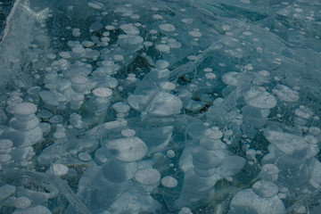CLOSE UP: Detailed shot of frozen Lake Abraham full of big methane bubbles.