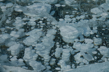 CLOSE UP: Fascinating view of big air bubbles trapped in frozen Lake Abraham.