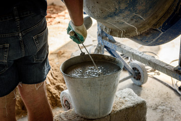 Construction worker making concrete in the mixer.