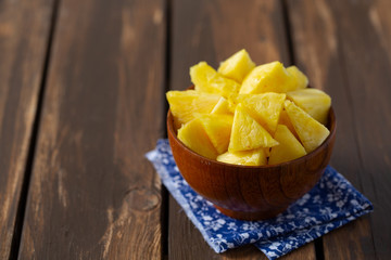 fresh pineapple pieces on wooden surface