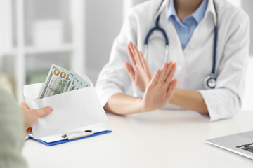 Doctor rejecting bribe in clinic, closeup. Corrupted medicine