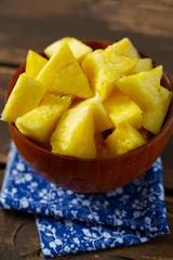 fresh pineapple pieces on wooden surface