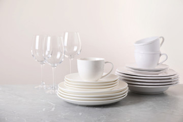 Set of clean tableware on light grey marble table