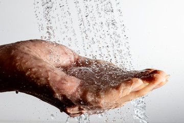 Falling water drops and human hand.