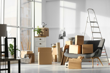 Cardboard boxes and household stuff in living room. Moving day
