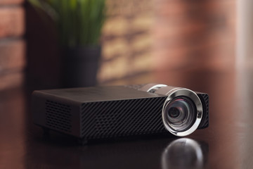 Modern video projector on wooden table indoors