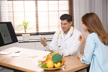 Nutritionist consulting patient at table in clinic