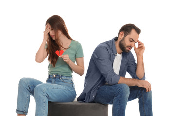 Woman with torn paper heart near her boyfriend on white background. Relationship problems