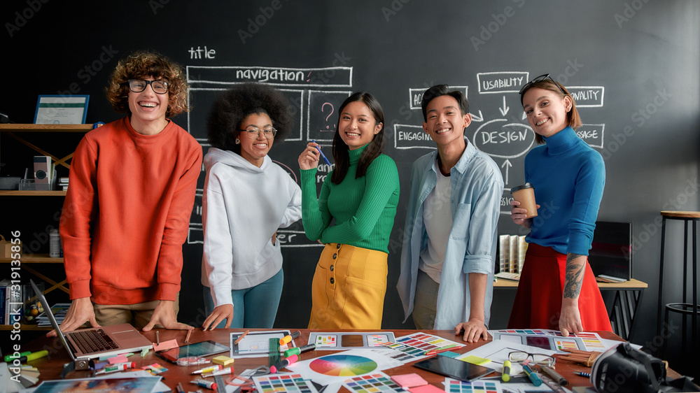 Poster professional web designers. portrait of creative designer team looking at camera and smiling while w