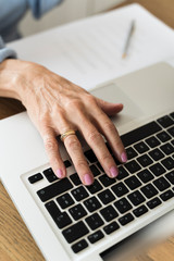 Closeup Adult woman's hand typing on laptop