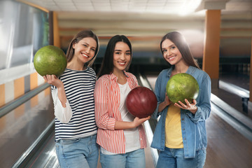 Fototapeta premium Group of young women with balls in bowling club