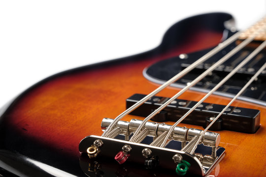 Close Up to the bridge and body part of Sunburst 4 string jazz bass guitar isolated on white background.