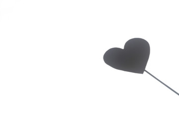 heart shadow on a stick on a textured white background