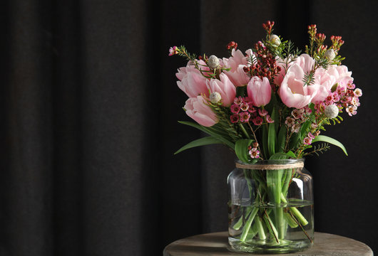 Beautiful bouquet with spring pink tulips on wooden table. Space for text