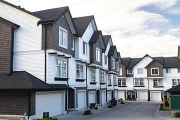 Brand new townhouses with concrete pavement in front. Front side of townhouses on sunny day in Canada.