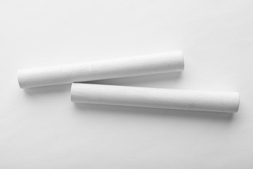 Pieces of chalk on white background, top view