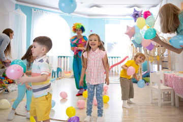 Kids group and clown have fun and play game at children's party
