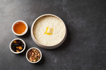 Rice porridge with milk, raisins, honey and nuts in a bowl.