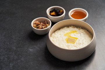 Rice porridge with milk, raisins, honey and nuts in a bowl.
