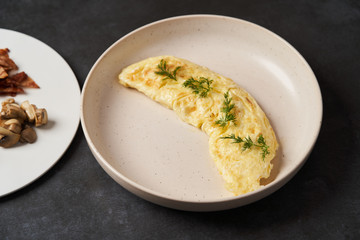 Traditional breakfast omelette with bacon, tomatoes, mushrooms, onion