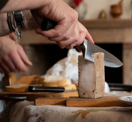 Fototapeta na wymiar Man slicing a block of lard with a chefs knife