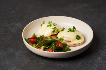 Eggs benedict with bacon meat and fish, close-up