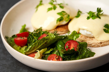 Eggs benedict with bacon meat and fish, close-up