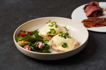 Eggs benedict with bacon meat and fish, close-up