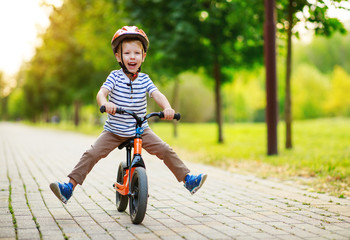 happy child boy rides a racetrack in Park in summer - obrazy, fototapety, plakaty