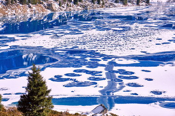 Bizarre forms of ice on the frozen mountain lake in winter season; variety of shapes in nature concept
