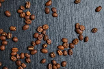Roasted coffee beans on a slate board. Top view.