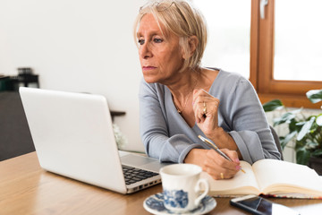 senior woman working on her laptop at home